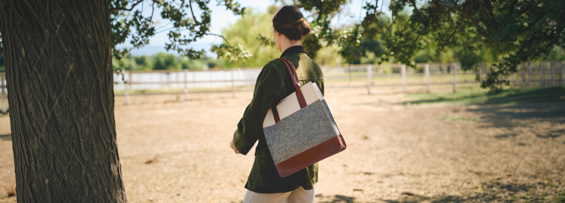 A person in a light dress holds a large handbag against a green leafy background. Text reads: 30% Off Bags - Spring Clean Sale. *Excludes everyday icons and final sale.