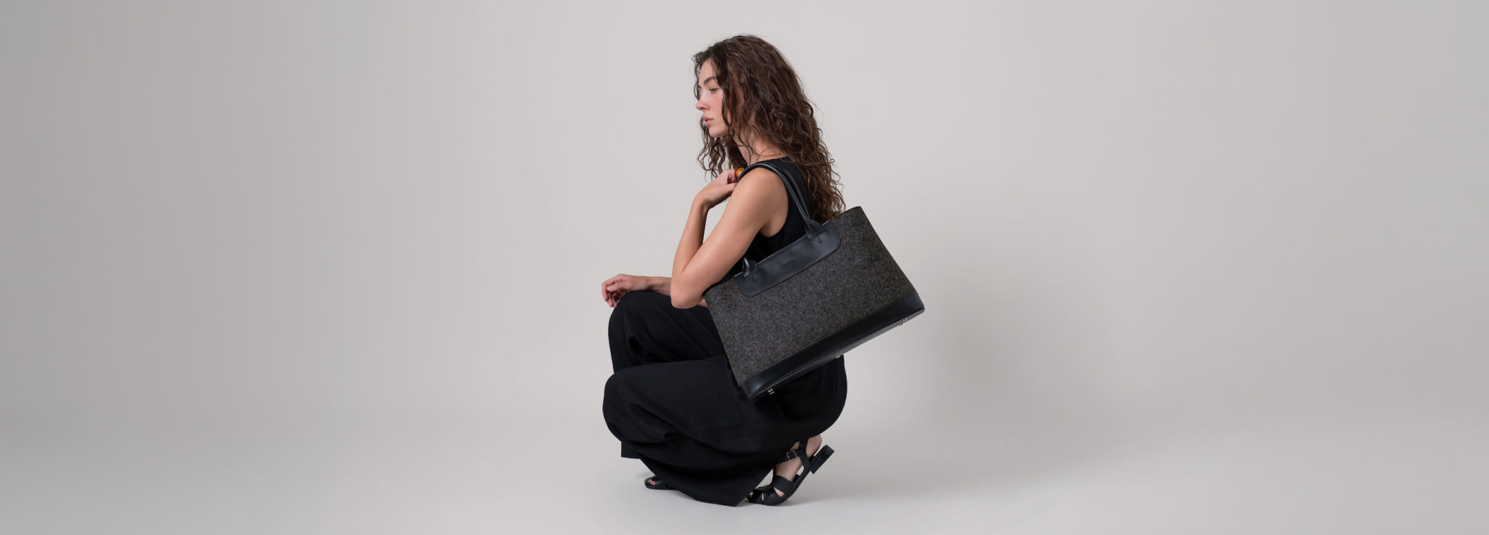 Merino Wool coasters in different shapes and colors by Graf Lantz and leather coaster holders on a wooden tabletop