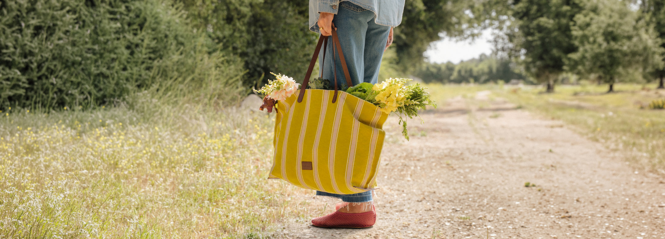 Woman sitting in green grass next to yellow Hako Cotton Canvas Tote bag by Graf Lantz