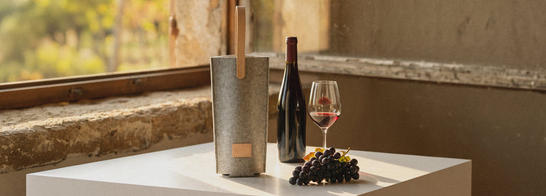 A collection of neatly arranged gift boxes, coasters, felt leaf shapes, a red wine bottle holder, tissue box, and coffee filters on an olive-green background.