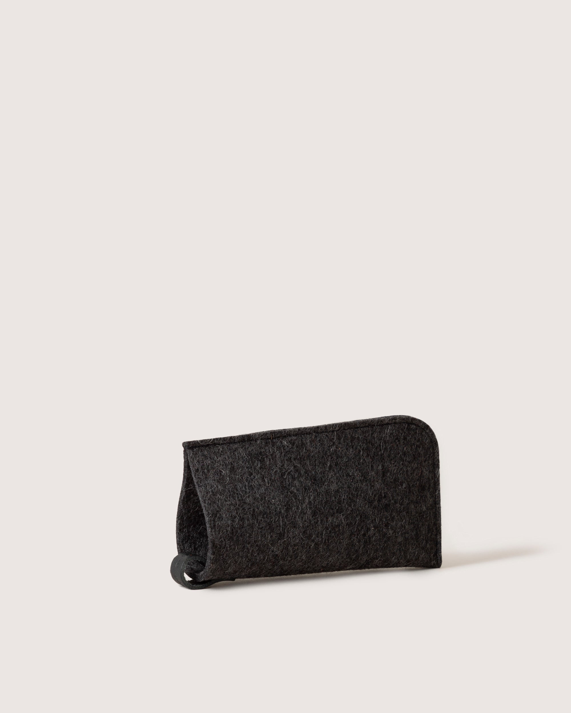 A graf lantz dark gray felt eyeglass sleeve stands upright on a white background, providing stylish protection for eyewear.