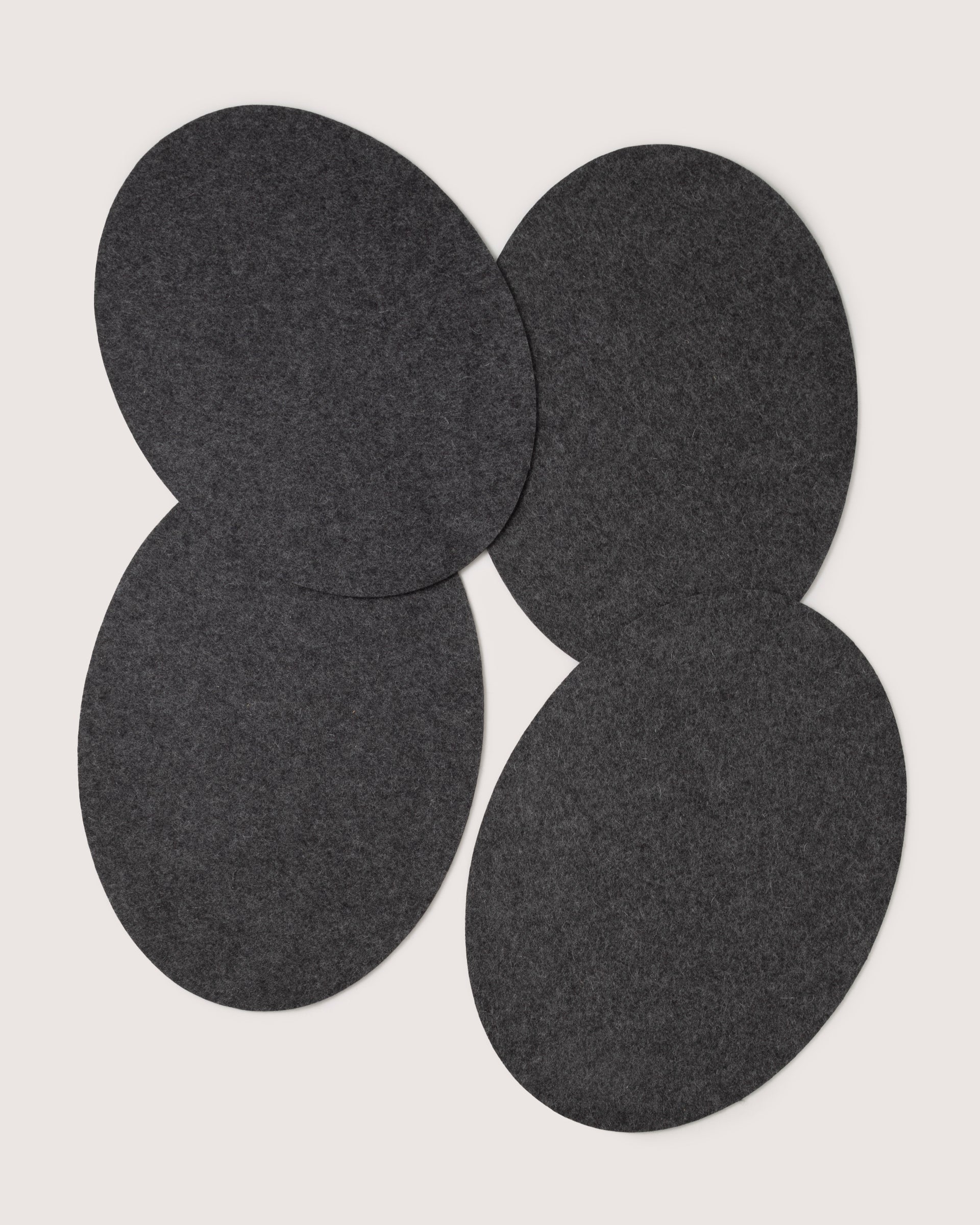 Four overlapping dark gray ovals form a symmetrical, designer-inspired pattern on a plain white background, reflecting graf lantzs style.