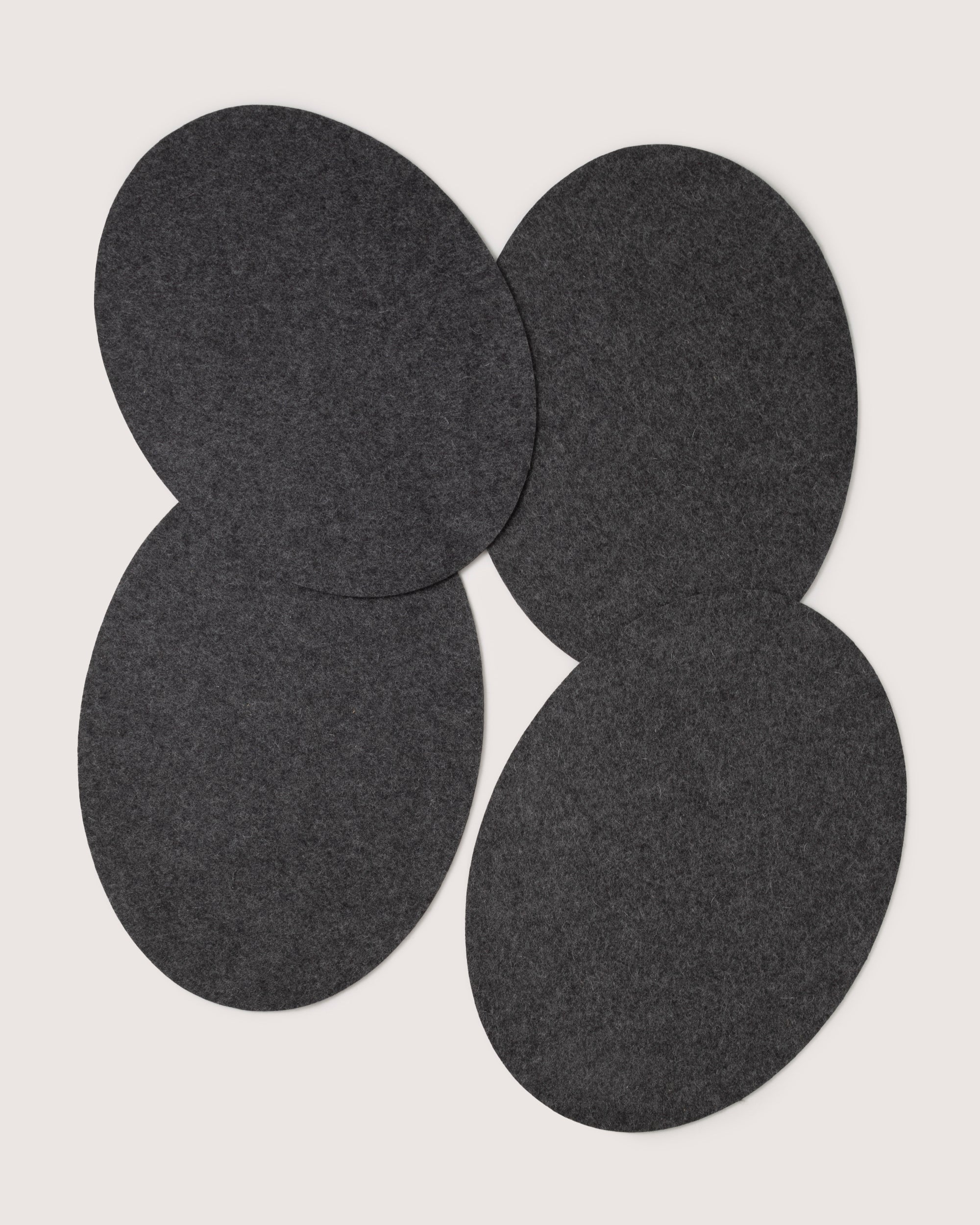 Four overlapping dark gray ovals form a symmetrical, designer-inspired pattern on a plain white background, reflecting graf lantzs style.