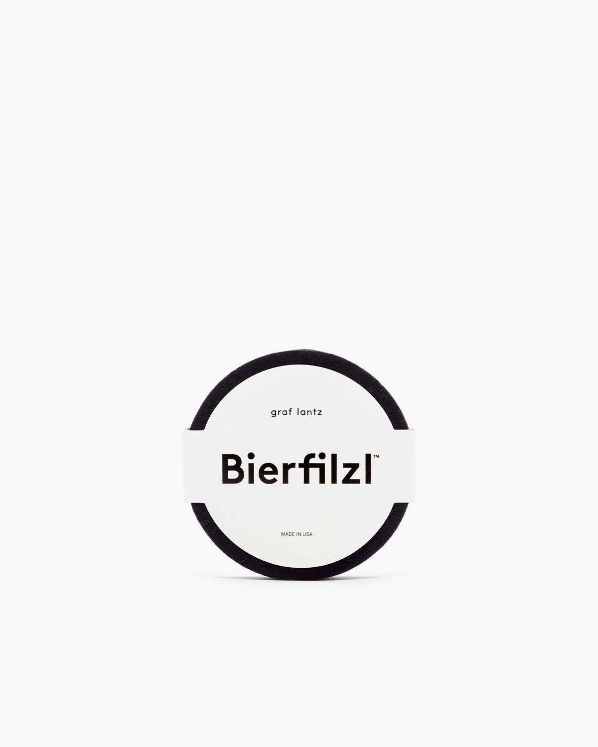 A Bierfilzl Merino Wool Round Coaster from a 4-pack, crafted from German Merino wool, is black with a label reading Bierfilzl, graf lantz, and MADE IN USA displayed on a plain white background.
